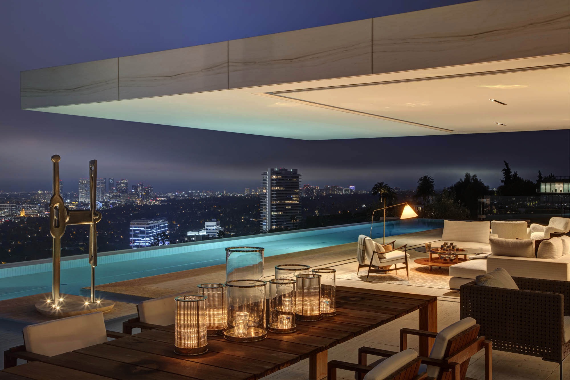 A rooftop terrace overlooking a city at night